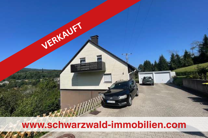 Verkauft(1) seitensicht eines hauses mit auto davor und doppelgarage