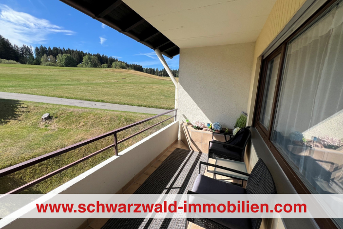 Titelbild mit Banner 704×470 ein balkon mit stühlen darauf und ein blick auf eine wiese